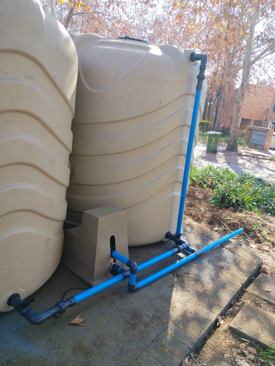 BoreFixPro dual tank installation with blue pipe reticulation connecting storage tanks at a residential complex