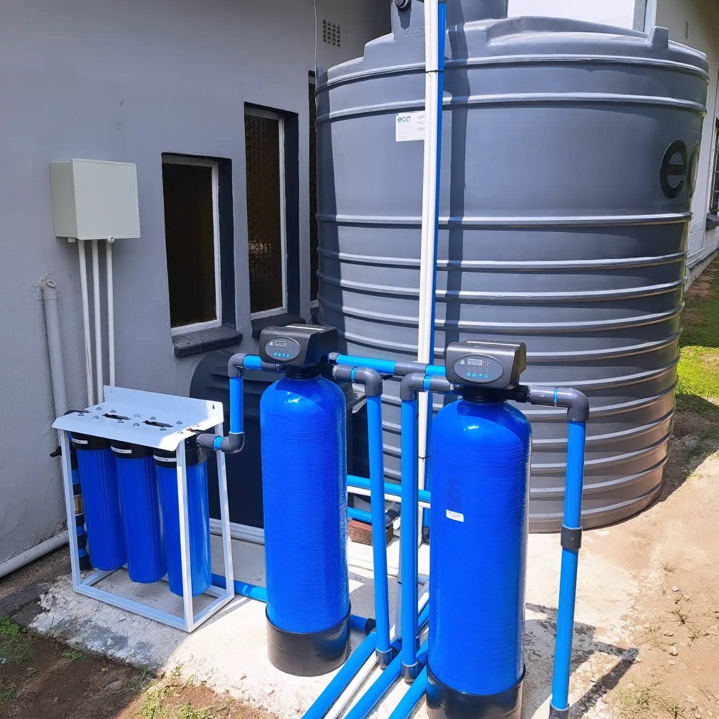 BoreFixPro multi-stage filtration system with blue filter vessels and eco storage tank installed at a residential property