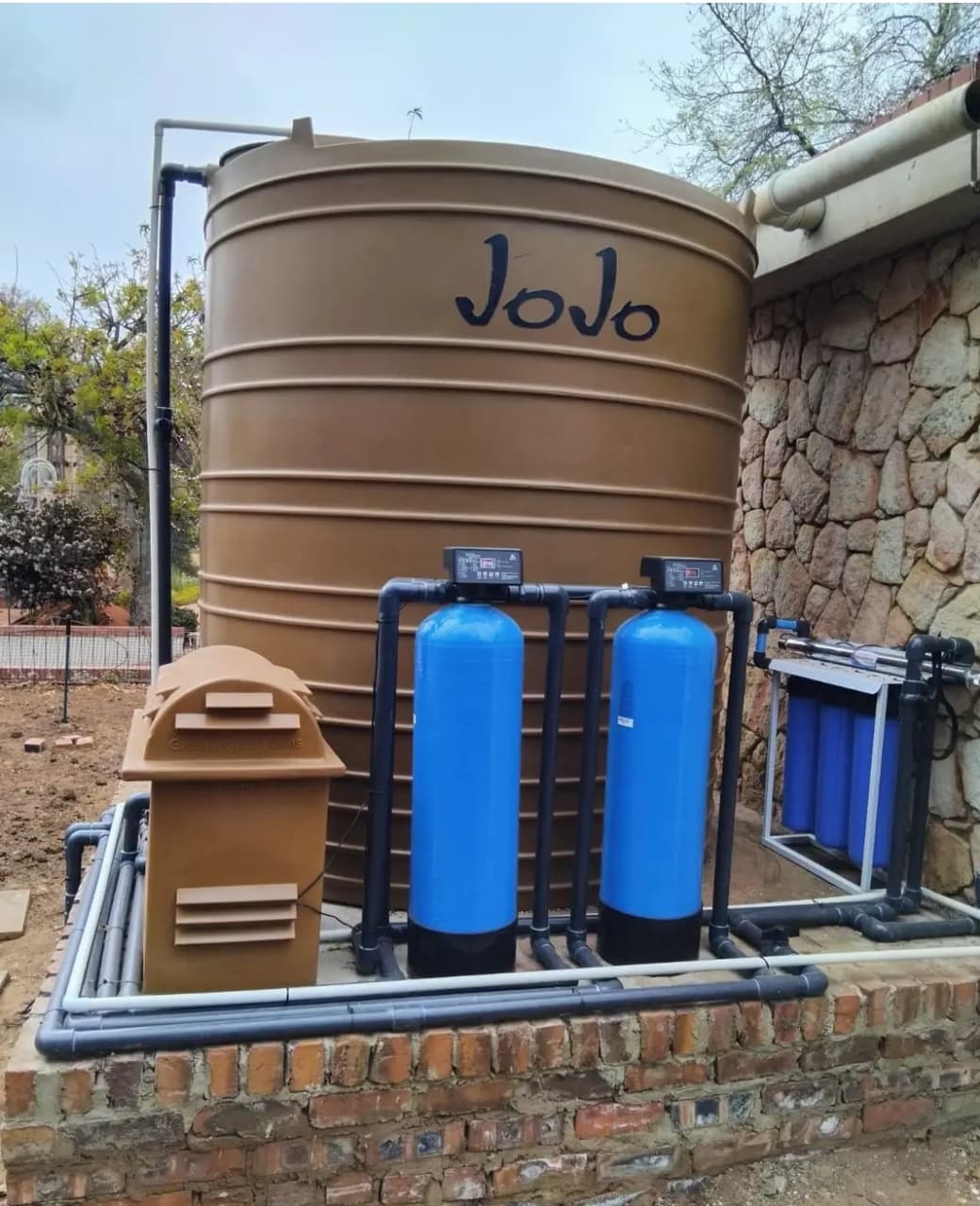 BoreFixPro JoJo storage tank with dual filtration vessels and blue pipe reticulation installed on brick plinth